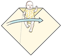 Schritt 1 beim Pucken: Das Baby liegt auf der Decke, wobei der Pfeil anzeigt, dass die linke Ecke über seinen Körper gefaltet wird.